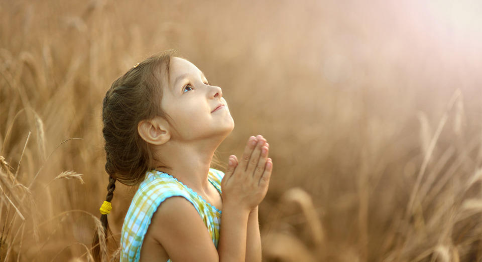 Young girl praying and looking up.